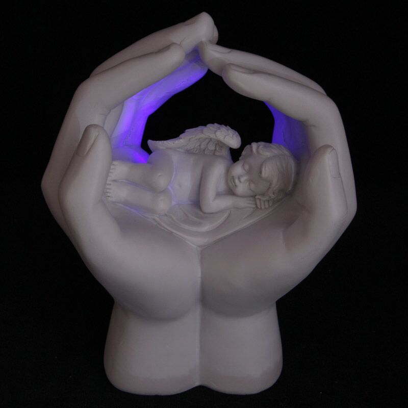 Śpiąca cherub w rękach z diodą LED